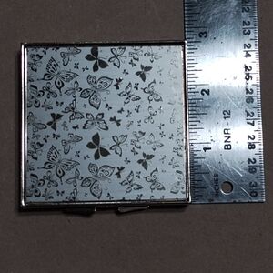 Gold tone vintage style 7 day pill box. With little butterfly design.